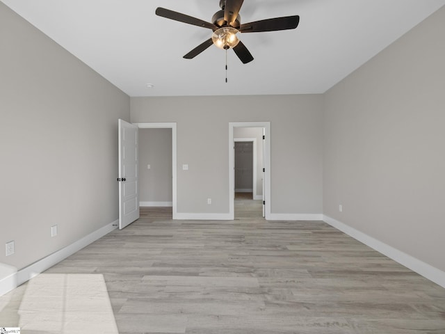 unfurnished bedroom featuring ceiling fan, light wood-type flooring, and a spacious closet