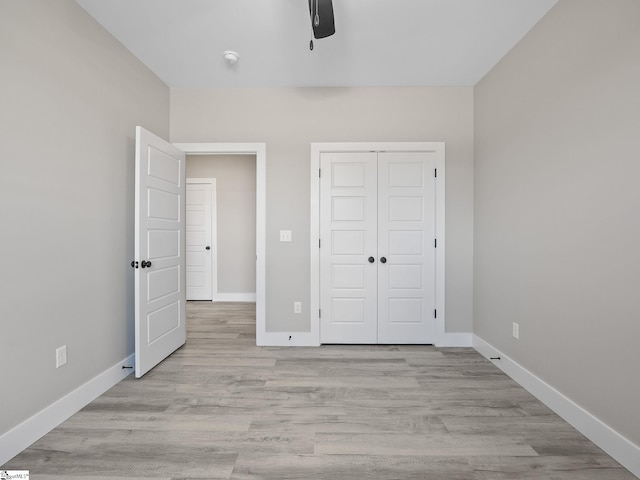 unfurnished bedroom with ceiling fan, light hardwood / wood-style floors, and a closet