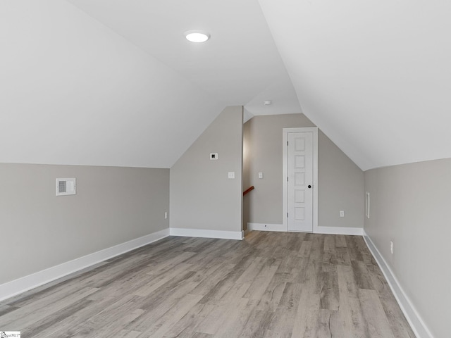 bonus room featuring lofted ceiling and light hardwood / wood-style flooring