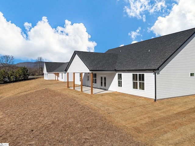 rear view of house with a mountain view and a patio area