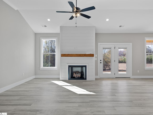 unfurnished living room with a fireplace, vaulted ceiling, light hardwood / wood-style flooring, and ceiling fan