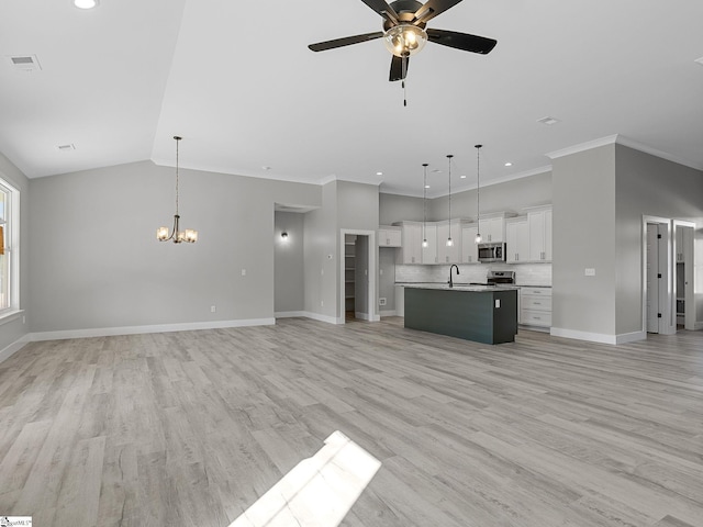 unfurnished living room with light hardwood / wood-style flooring, ornamental molding, ceiling fan with notable chandelier, and sink