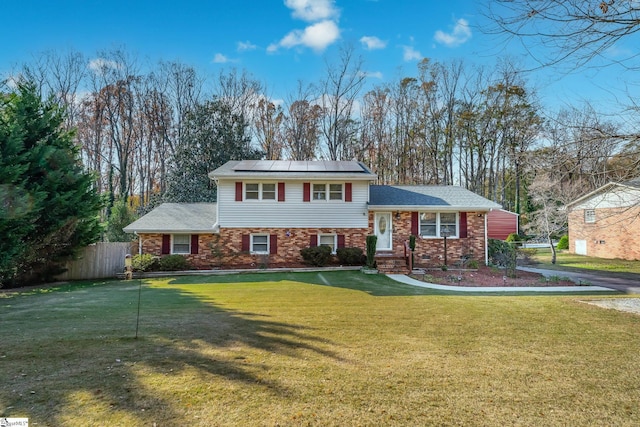 split level home featuring a front yard and solar panels