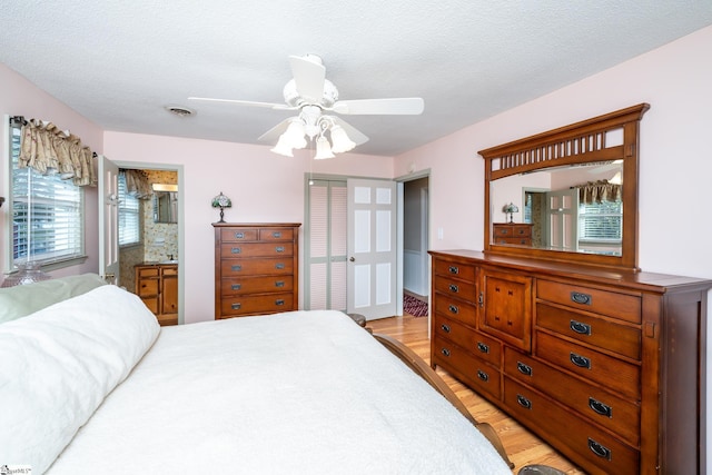 bedroom featuring ceiling fan, connected bathroom, a closet, and a textured ceiling