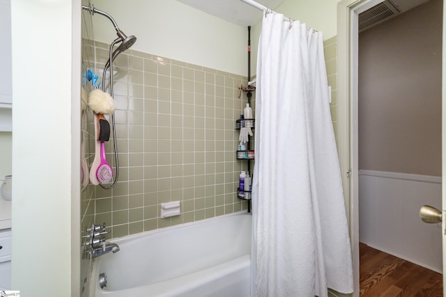 bathroom featuring wood-type flooring and shower / bath combo with shower curtain