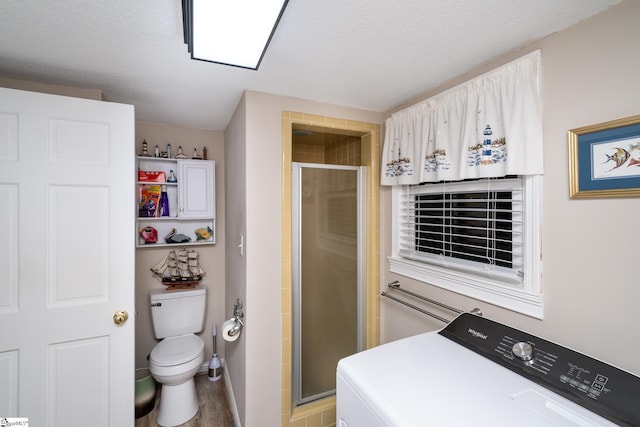 washroom with washer / clothes dryer, hardwood / wood-style floors, and a textured ceiling