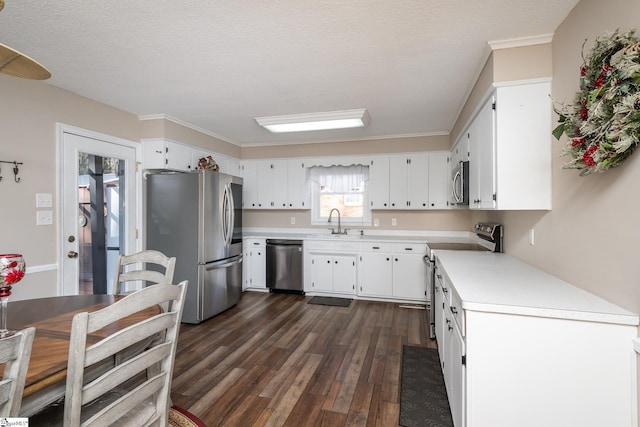 kitchen featuring dark wood-type flooring, sink, white cabinetry, a textured ceiling, and stainless steel appliances