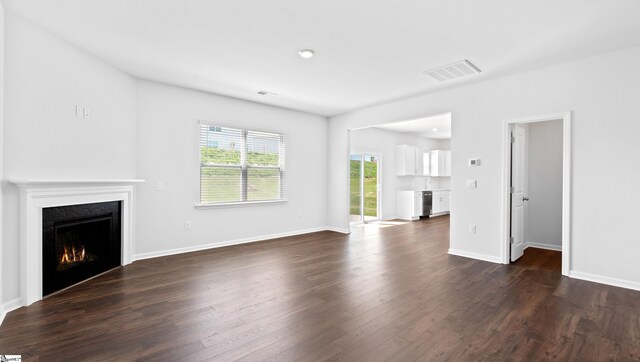 305 Lodestone Rd Lot 0267, Simpsonville, SC 29680 - unfurnished living room featuring baseboards, visible vents, dark wood-style floors, and a lit fireplace