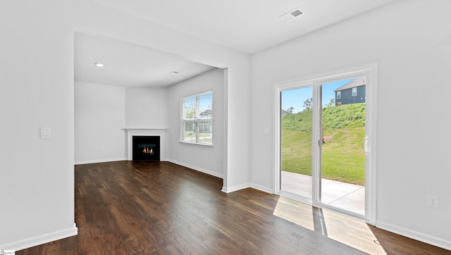 305 Lodestone Rd Lot 0267, Simpsonville, SC 29680 - unfurnished living room with a warm lit fireplace, dark wood-type flooring, visible vents, and baseboards