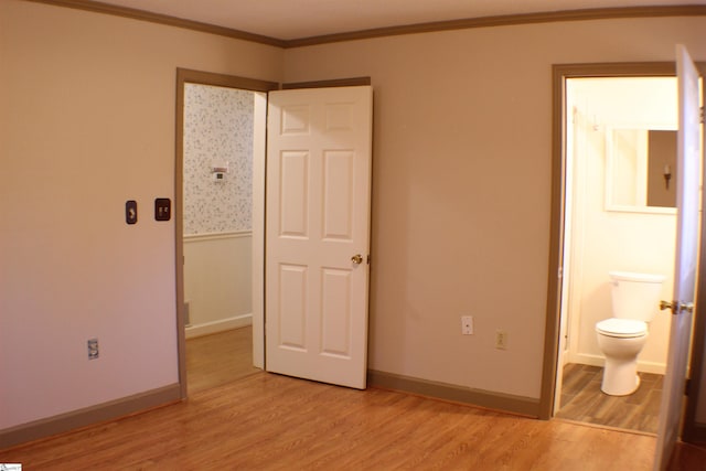 unfurnished bedroom featuring connected bathroom, ornamental molding, and light hardwood / wood-style floors