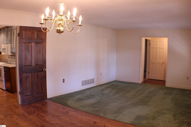 unfurnished dining area with crown molding, dark wood-type flooring, and an inviting chandelier