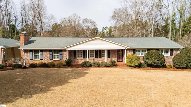 ranch-style home with covered porch and a front yard