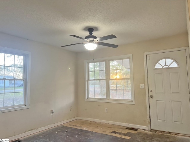 foyer entrance featuring a textured ceiling and ceiling fan