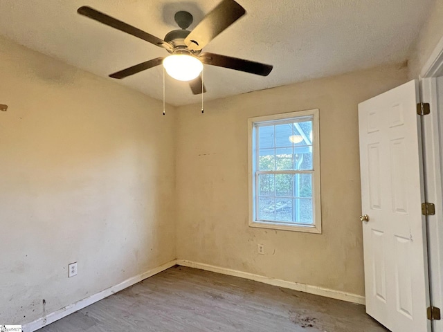 spare room featuring ceiling fan, hardwood / wood-style floors, and a textured ceiling