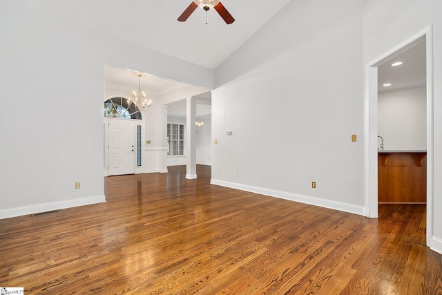 unfurnished living room featuring ceiling fan with notable chandelier, hardwood / wood-style flooring, crown molding, and lofted ceiling