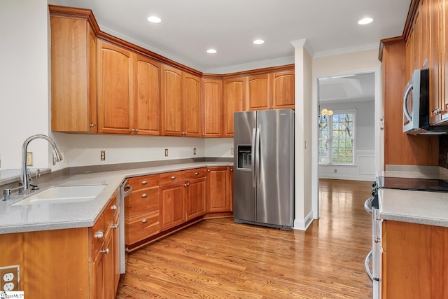 kitchen featuring appliances with stainless steel finishes, crown molding, sink, an inviting chandelier, and light hardwood / wood-style floors