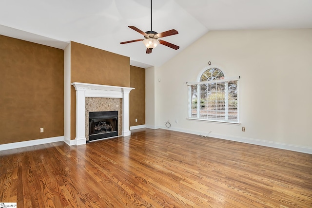 unfurnished living room featuring ceiling fan, a fireplace, wood-type flooring, and vaulted ceiling