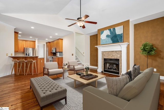 living room featuring hardwood / wood-style flooring, ceiling fan, and lofted ceiling