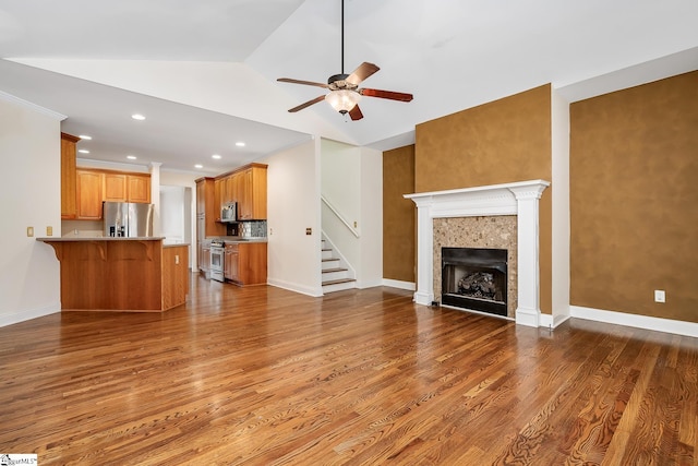 unfurnished living room featuring ceiling fan, wood-type flooring, and lofted ceiling