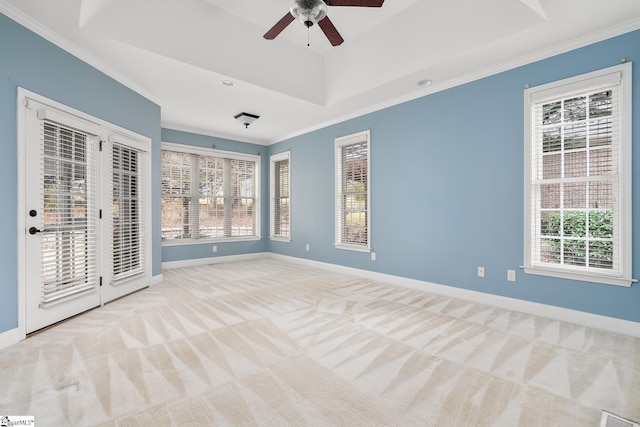 unfurnished room featuring a wealth of natural light, crown molding, ceiling fan, and light colored carpet