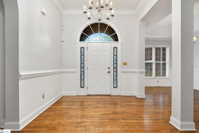 entryway with hardwood / wood-style flooring, a notable chandelier, and ornamental molding