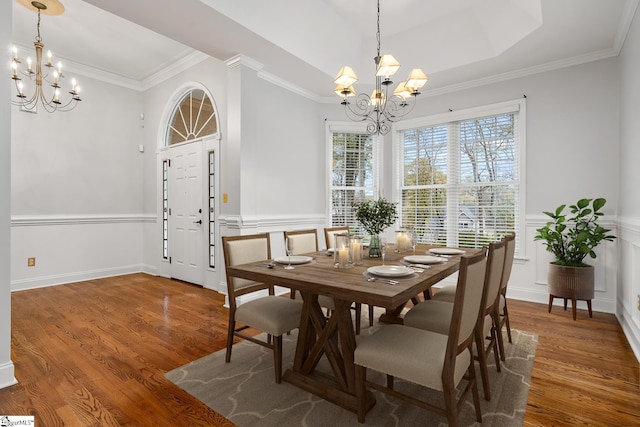 dining space featuring dark hardwood / wood-style flooring, crown molding, and an inviting chandelier