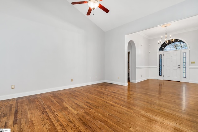 entrance foyer featuring light hardwood / wood-style flooring, high vaulted ceiling, ceiling fan with notable chandelier, and ornamental molding