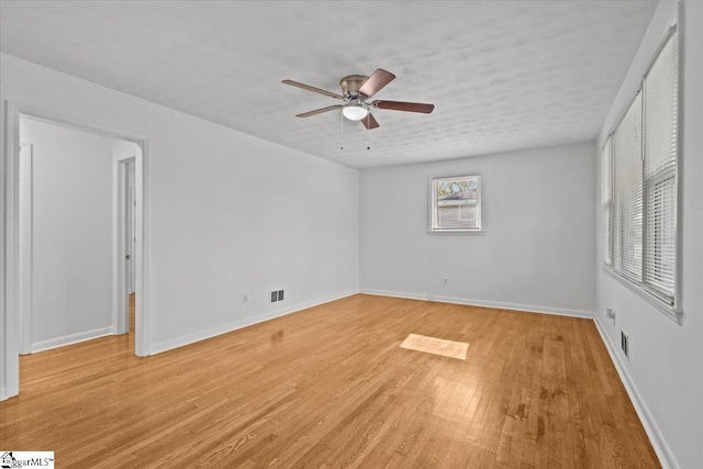 unfurnished room with a textured ceiling, light hardwood / wood-style floors, and ceiling fan