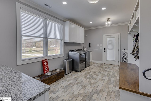 laundry area with crown molding, sink, cabinets, and independent washer and dryer