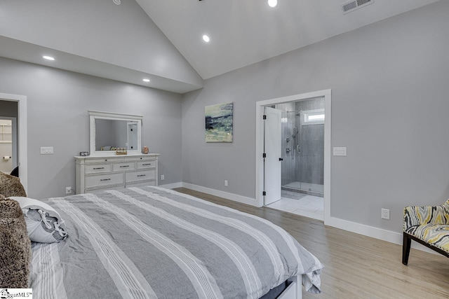 bedroom featuring ensuite bathroom, high vaulted ceiling, and light hardwood / wood-style flooring