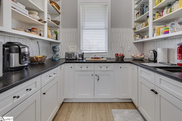 kitchen featuring white cabinetry, backsplash, and light hardwood / wood-style flooring