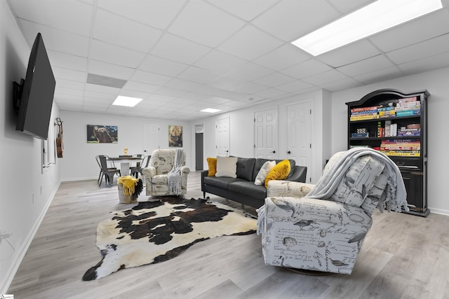 living room with light wood-type flooring and a drop ceiling