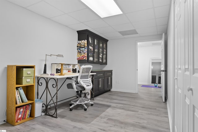 office space featuring a paneled ceiling and light hardwood / wood-style flooring