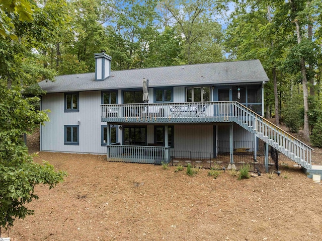 rear view of house with a sunroom and a deck