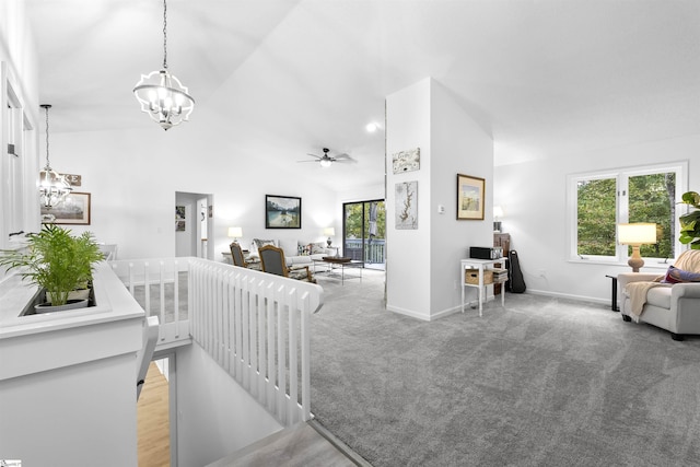 living room featuring light carpet, ceiling fan with notable chandelier, and vaulted ceiling