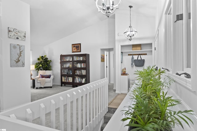 interior space featuring carpet flooring, high vaulted ceiling, and a chandelier