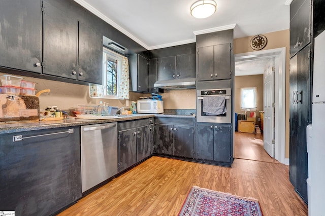 kitchen featuring appliances with stainless steel finishes, light hardwood / wood-style flooring, and crown molding