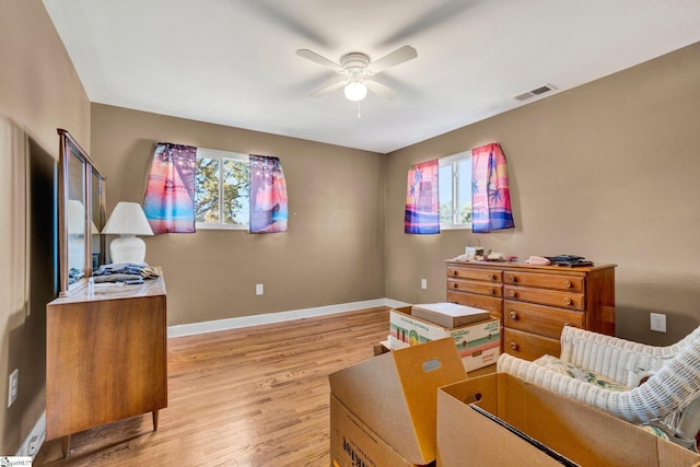 living area with light hardwood / wood-style floors and ceiling fan