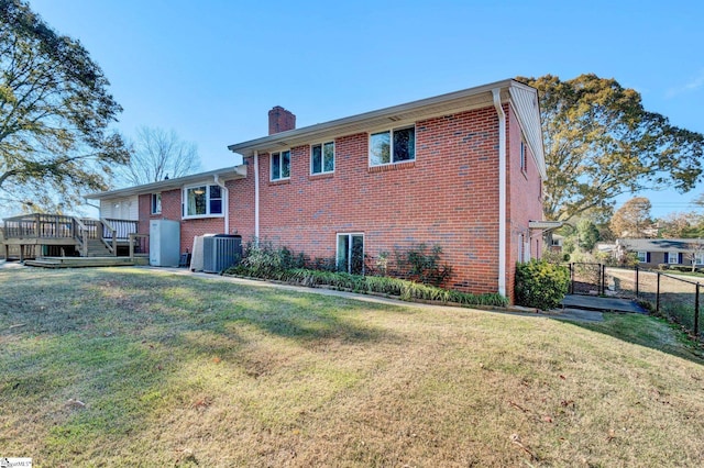 back of property with a yard, central air condition unit, and a wooden deck