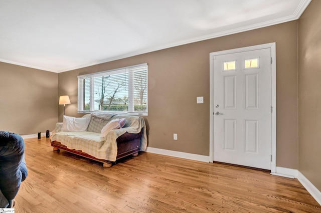 foyer with light wood-type flooring and ornamental molding