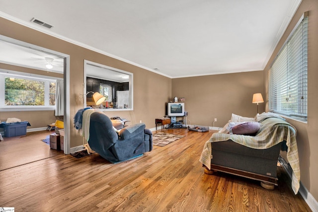 living room with ceiling fan, ornamental molding, and hardwood / wood-style flooring