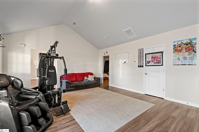 exercise area featuring wood-type flooring and vaulted ceiling