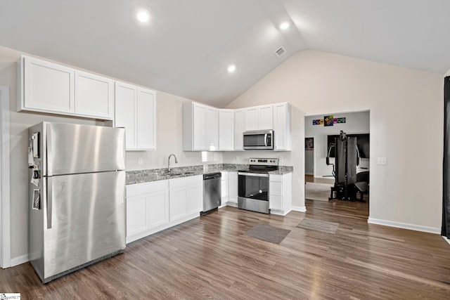 kitchen with white cabinets, stainless steel appliances, and light stone counters