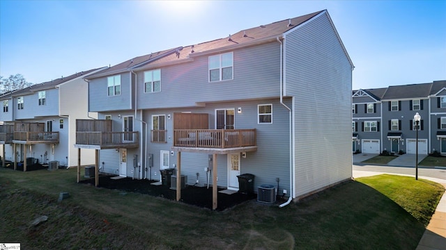 rear view of house with a balcony, cooling unit, and a lawn