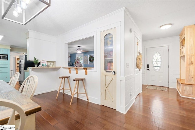 foyer with dark hardwood / wood-style floors, ceiling fan, and ornamental molding