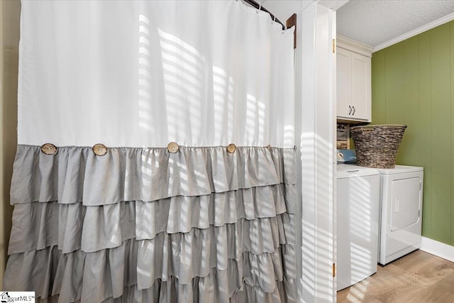 bathroom featuring wood-type flooring, a textured ceiling, washer and clothes dryer, and crown molding