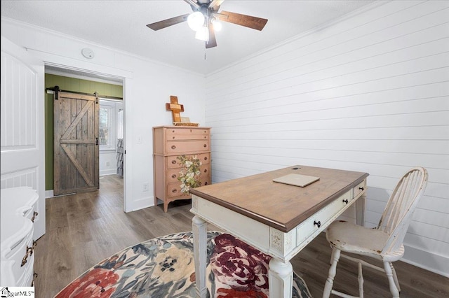 office area featuring hardwood / wood-style flooring, a barn door, and crown molding