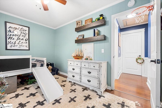 bedroom with ceiling fan, ornamental molding, and light wood-type flooring