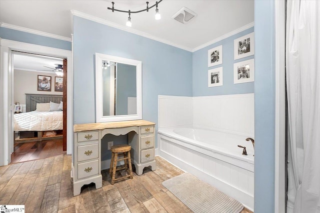 bathroom featuring crown molding, hardwood / wood-style floors, ceiling fan, and a bath