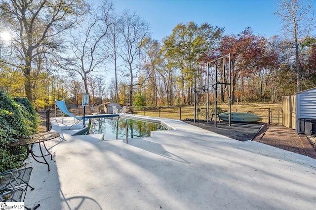 view of swimming pool with a shed and a water slide